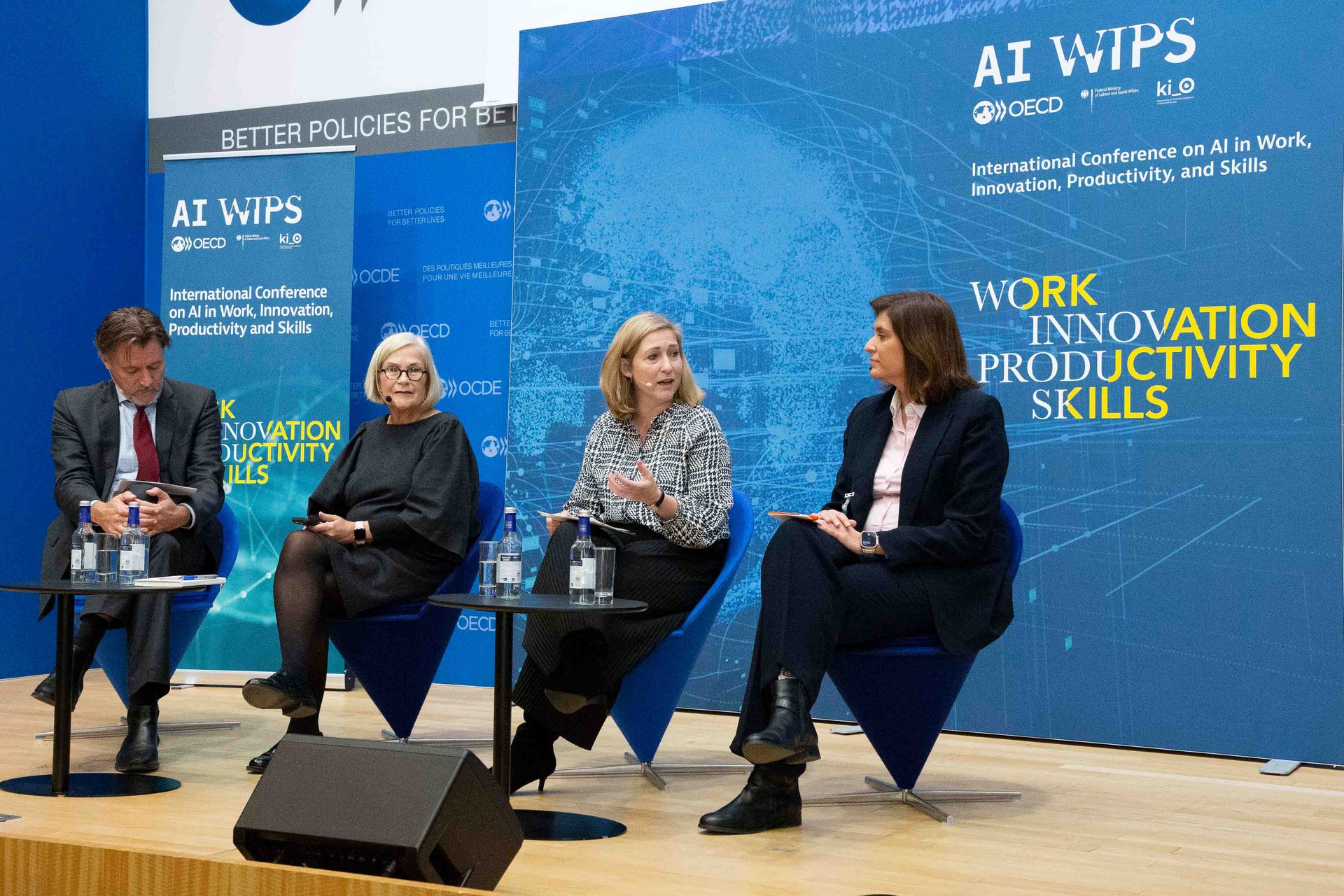 Ulrik Vestergaard Knudsen (OECD) moderiert die Paneldiskussion und tauscht sich mit den neben ihr sitzenden Christy Hoffman, Generalsekretärin der UNI Global Union, BMAS-Staatssekretärin Lilian Tschan, Christina Leimoni, Regional Director für den sozialen Einfluss von KI-Skills bei Microsoft EMEA (v.l.n.r.) aus.