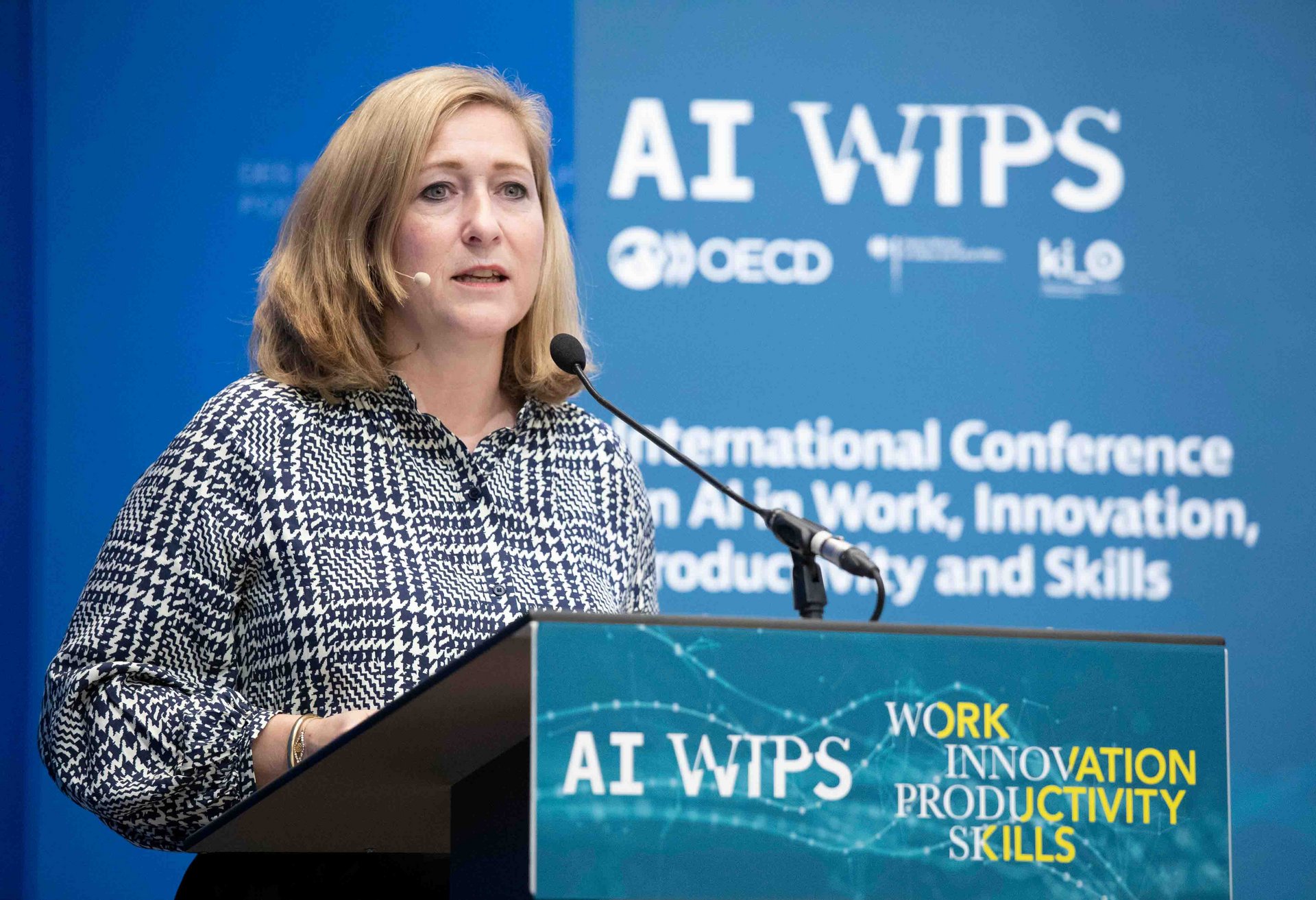 Lilian Tschan hinter einem Rednerpult beim Eröffnungspanel der AI-WIPS-Konferenz der OECD in Paris.